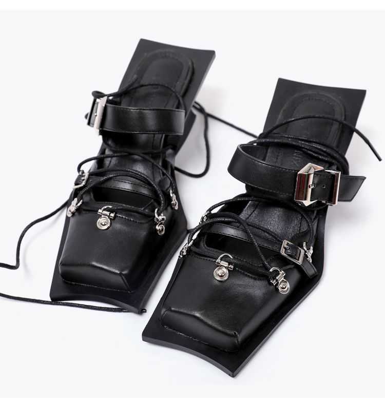 Pair of black leather anklets with silver buckles on a white background